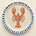 Ivory ceramic dinner plate hand-painted with a coral lobster and a cobalt brush-stroke rim