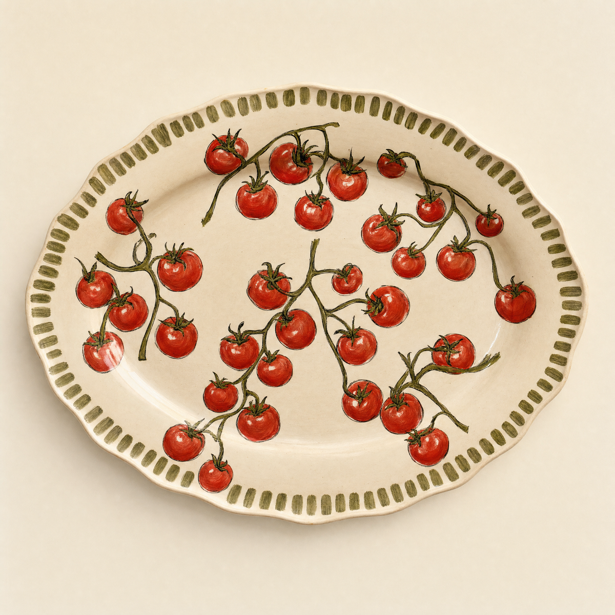 Large oval ivory ceramic serving platter hand-painted with scattered vine tomatoes and a scalloped olive rim